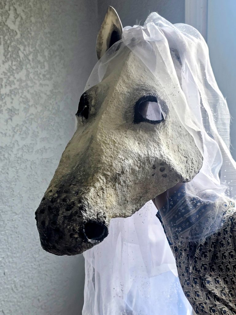 One of Monica Barela-Di Bisceglie's veiled horse-head puppets, built from a wire skeleton and stiffened fabric, for the production's mournful promenade section